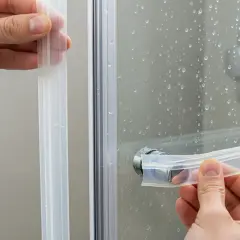 Applicazione guarnizione per box doccia ante scorrevoli. Dettaglio mani che inseriscono la guarnizione trasparente.