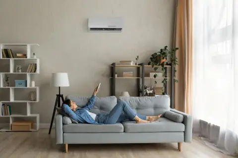 Soggiorno con pareti grigio moderno, divano comodo e aria condizionata. Perfetto per rilassarsi con un libro.