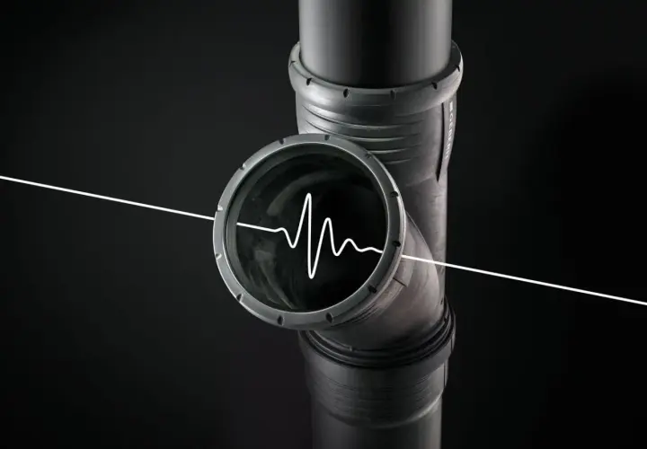 Un tubo di scarico con un'onda sonora bianca all'interno, che illustra perché lo scarico del bagno fa rumore.