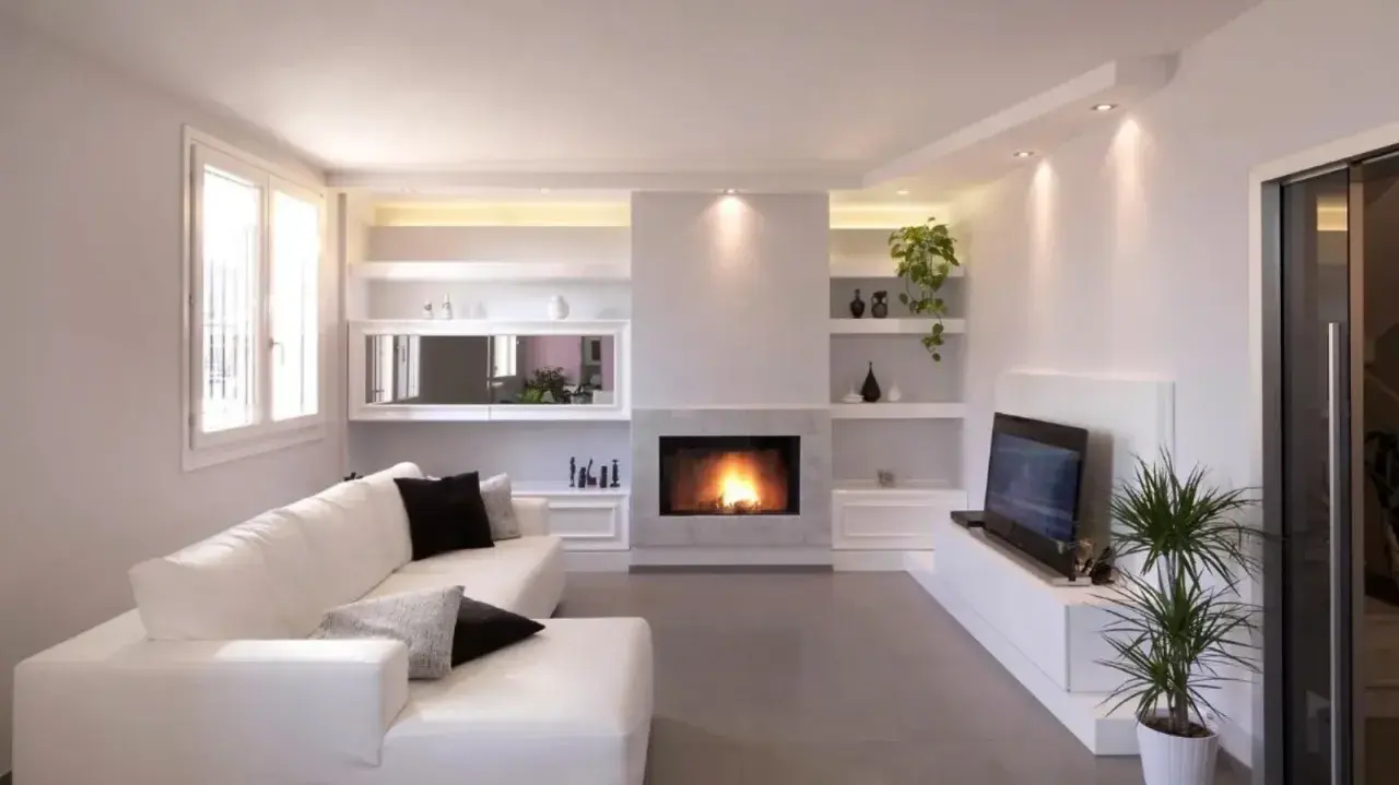 Soggiorno moderno con camino e TV, con una parete attrezzata in cartongesso che integra librerie e vani contenitori.