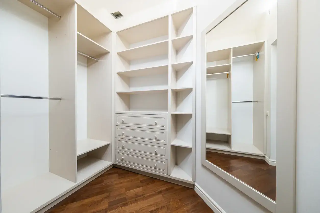 Spaziosa cabina armadio in cartongesso con mensole, cassettiera e specchio. Organizzazione perfetta per ogni guardaroba.